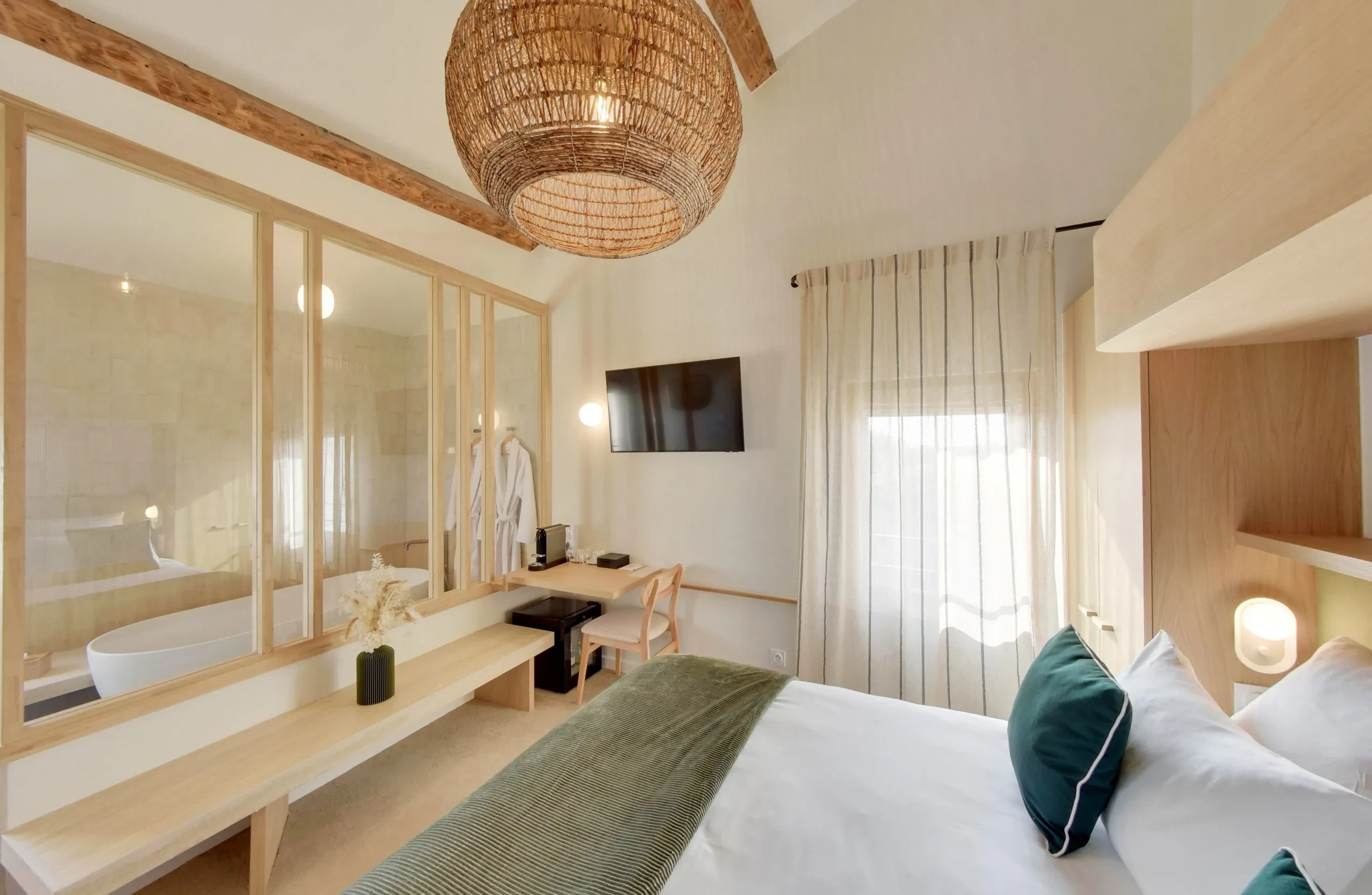 Chambre lumineuse avec baignoire et lit double.