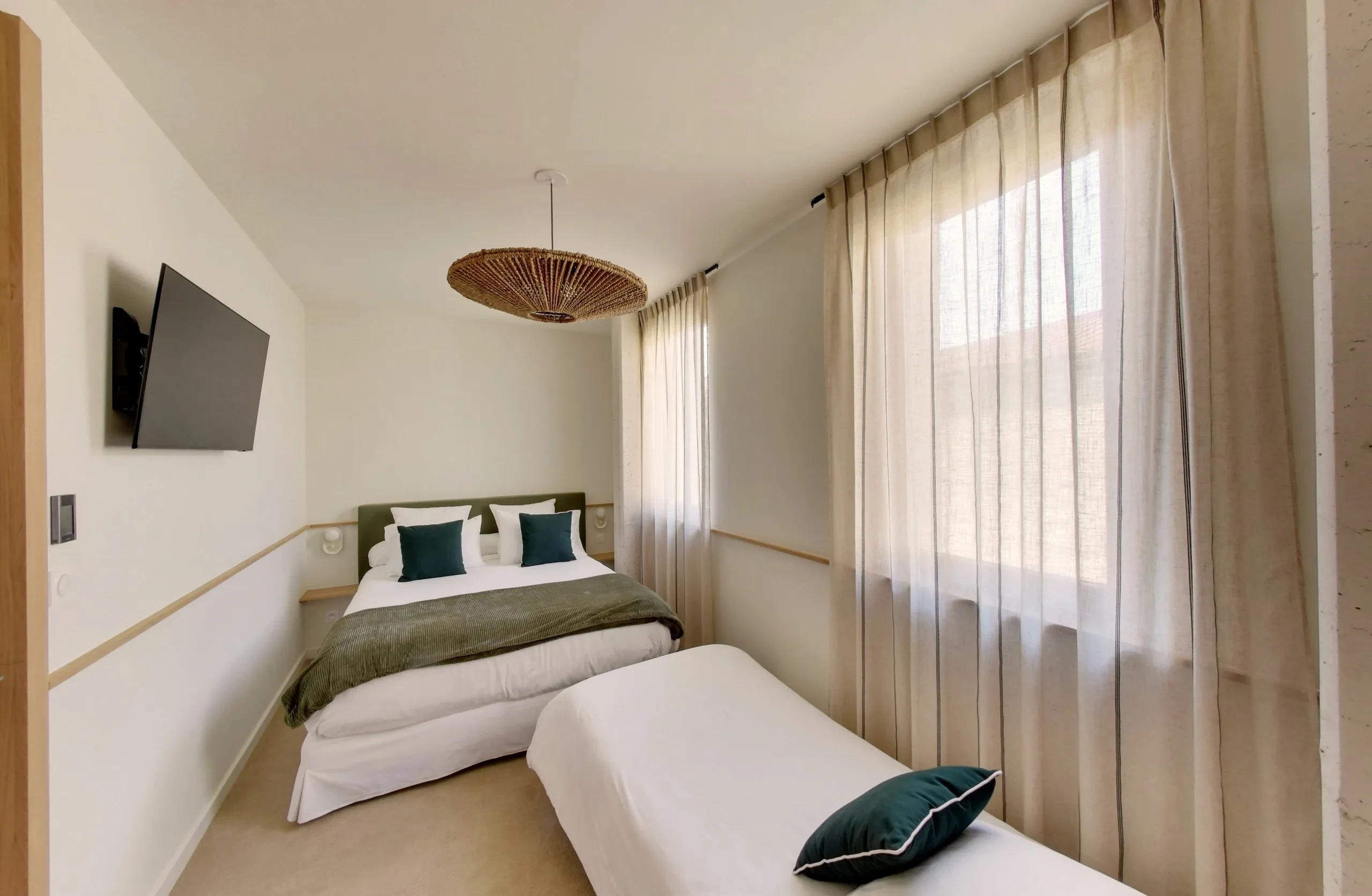 Chambre avec lit double et simple, télé murale.