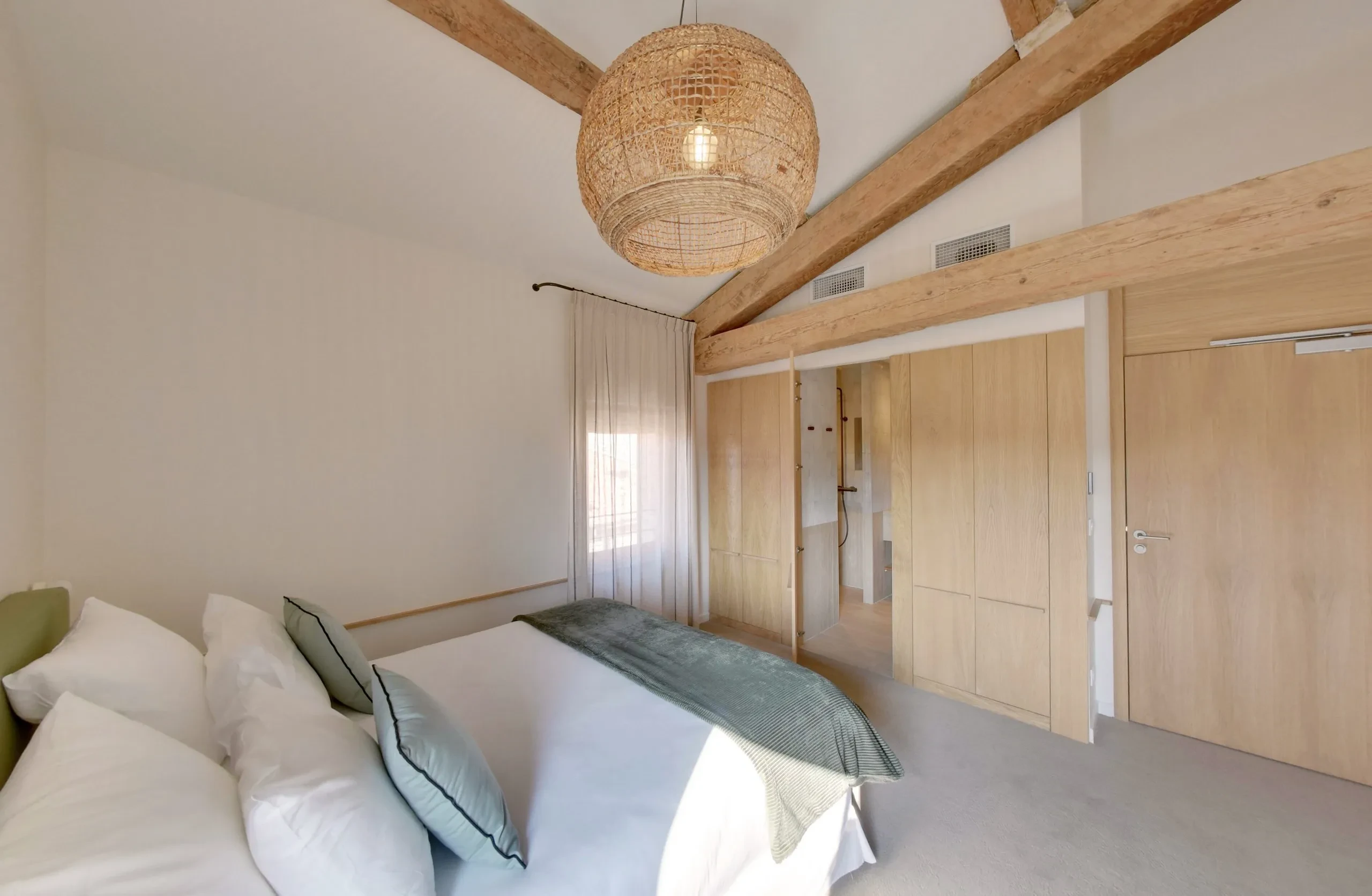 Chambre lumineuse avec lit et décoration naturelle.