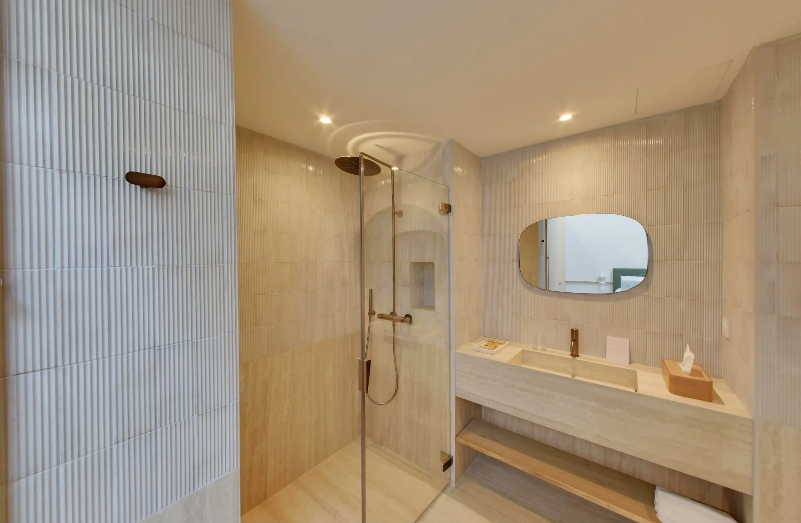 Salle de bain moderne avec douche et lavabo.