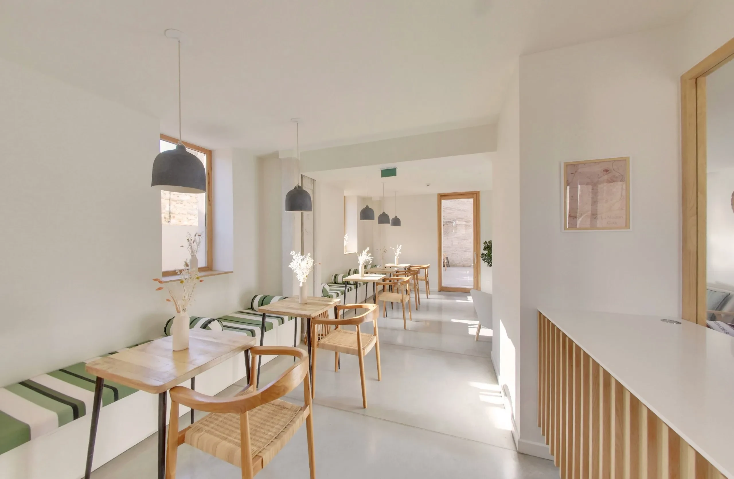 Salle à manger lumineuse avec tables en bois.