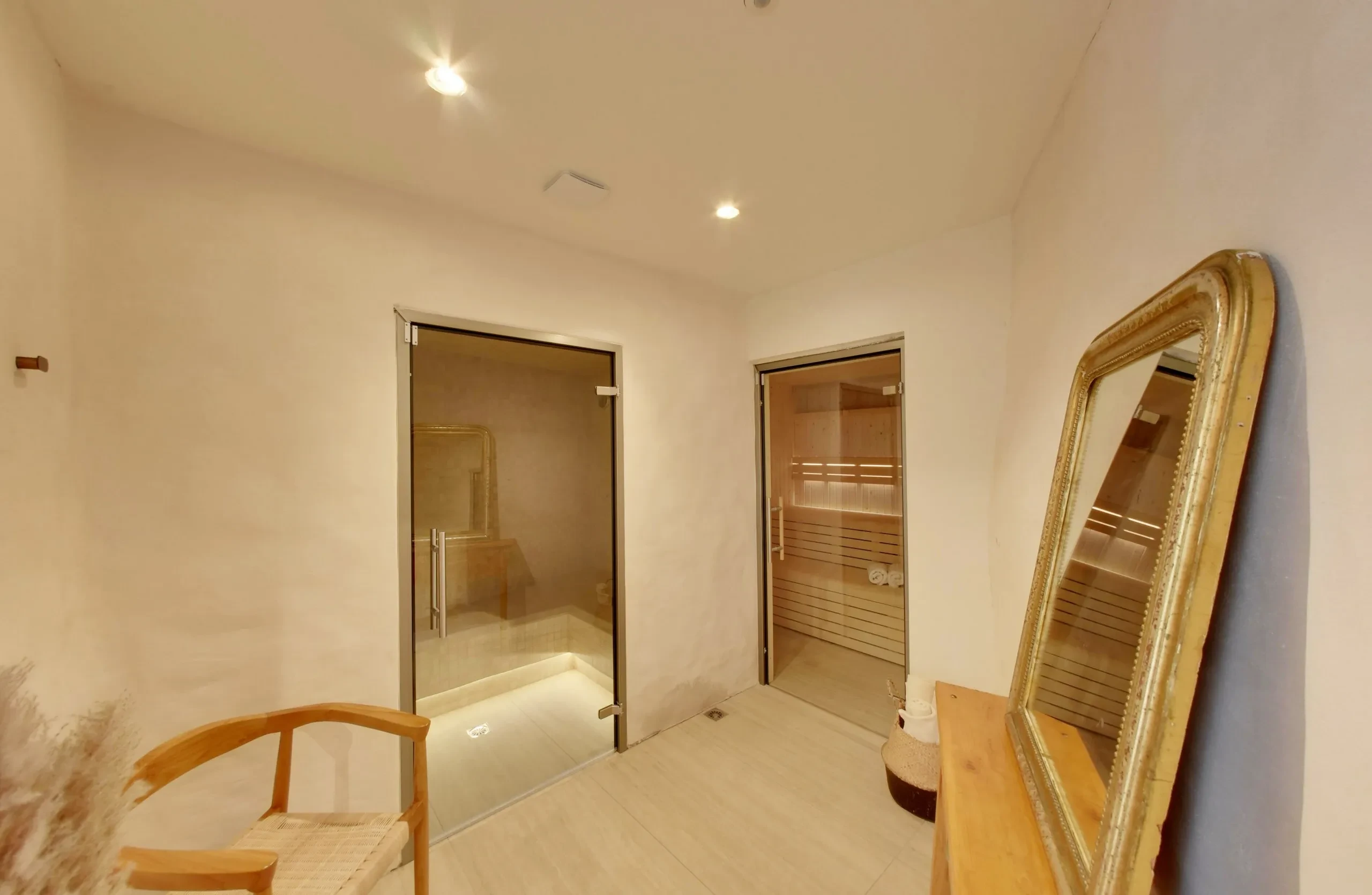 Salle avec sauna moderne et miroir doré.