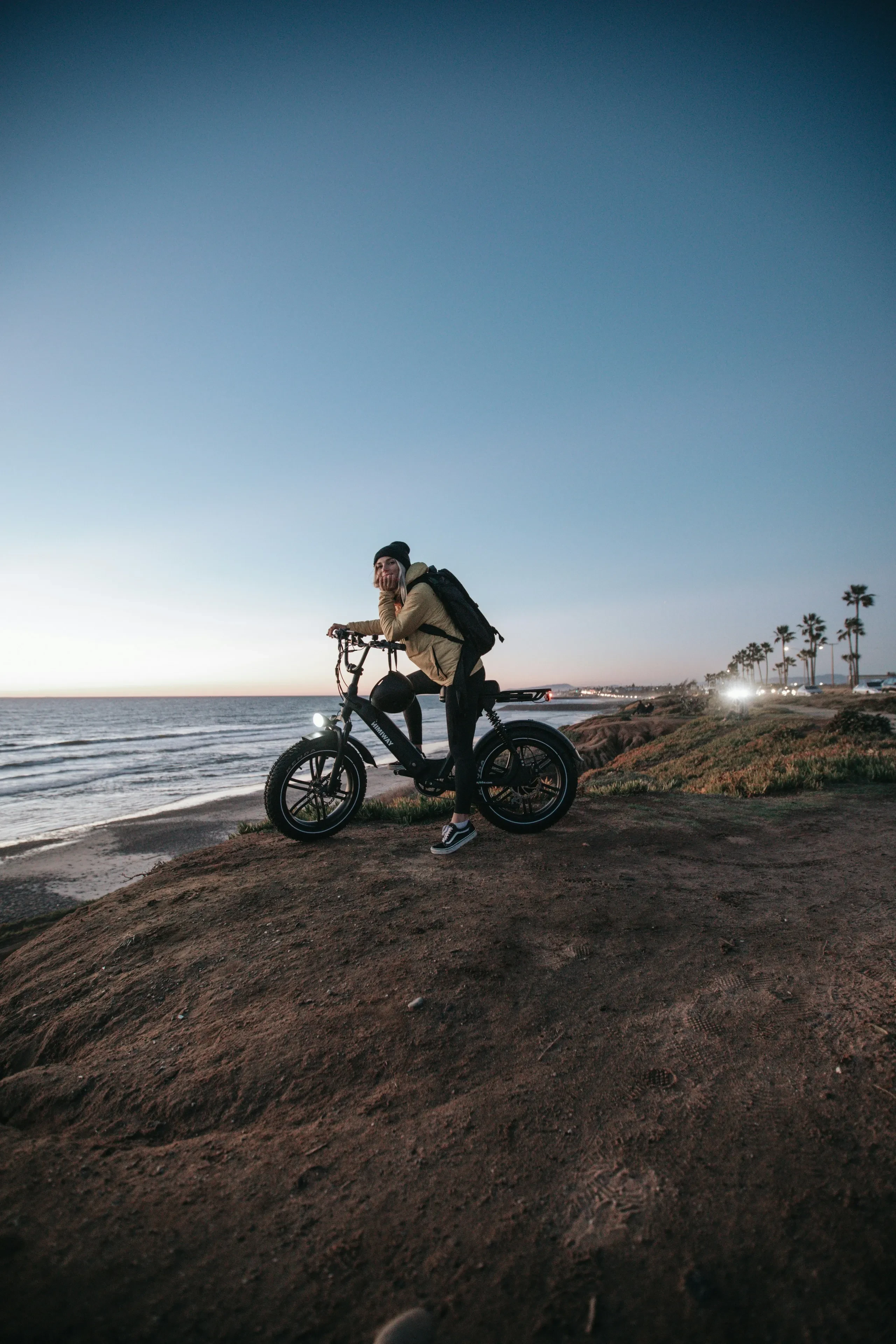 Personne sur vélo électrique devant la mer au coucher