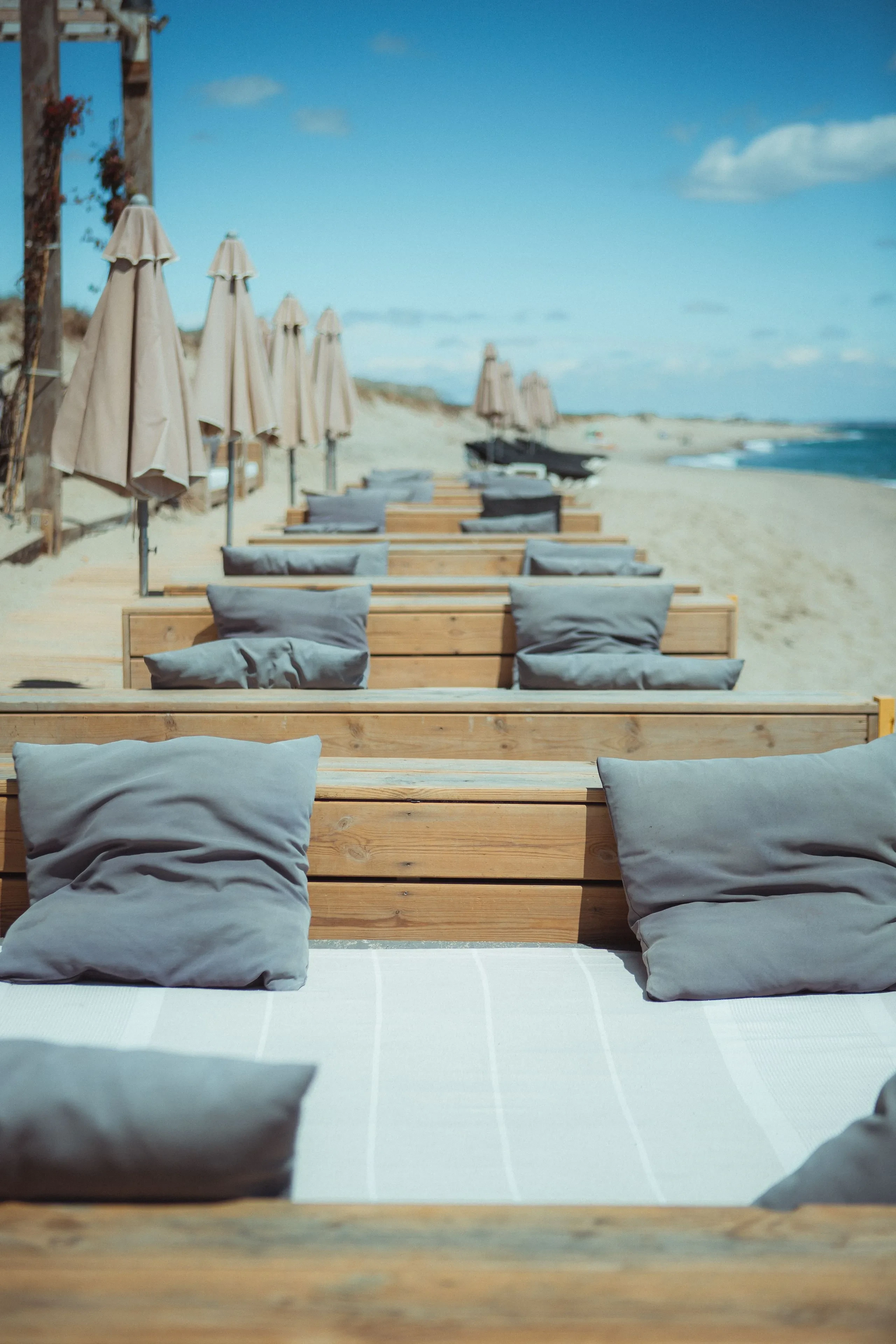Transats et parasols sur plage ensoleillée.