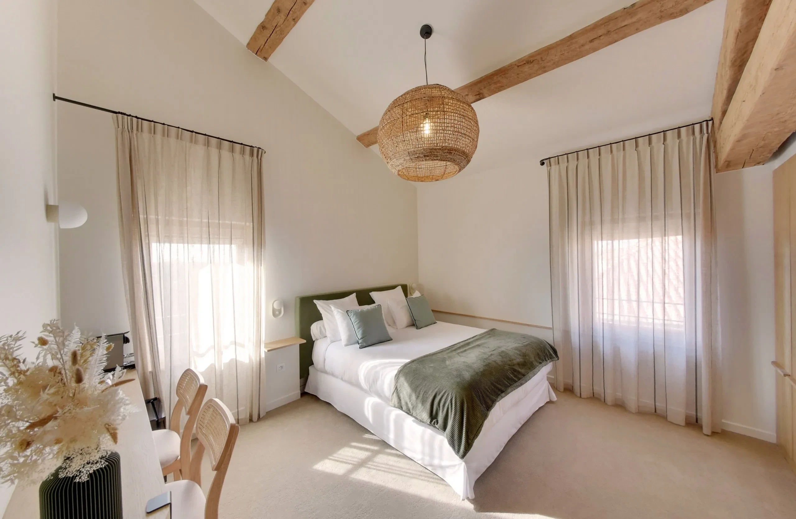 Chambre lumineuse avec lit double et décoration élégante.